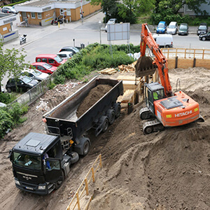 Bagger der einen LKW mit Bauschutt belädt
